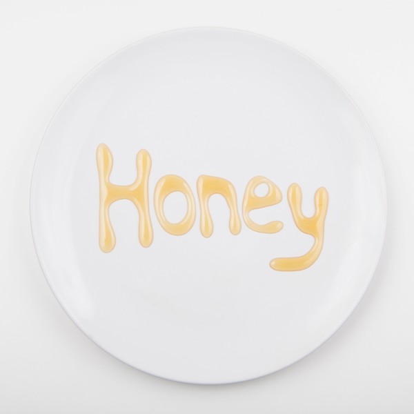Word HONEY on white plate. Photo : Jessica Peterson