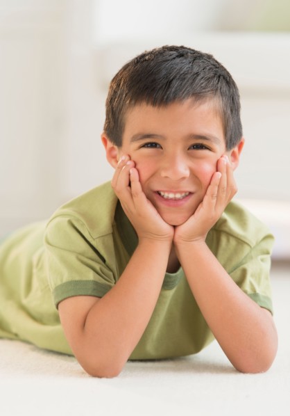 Portrait of boy (6-7) lying on carpet.