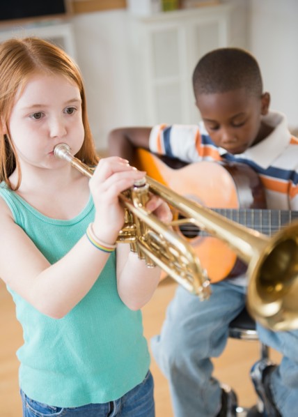 School children (8-9) with playing instruments during music class