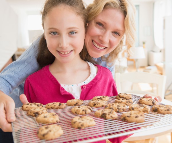 Mother and daughter (8-9 years) baking cookies