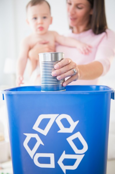 Mother and daughter (6-11 months) putting can into recycling bin