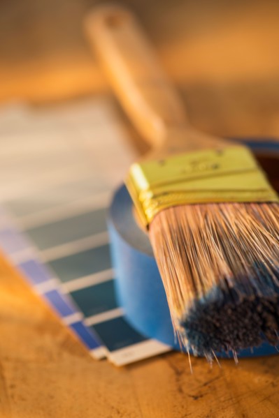 Elevated view of paintbrush, masking tape and color swatches