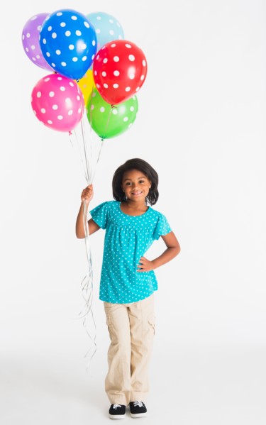 Studio shot of girl (6-7 years) holding colorful balloons