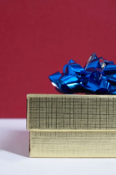 Studio shot of gift with blue bow on red background