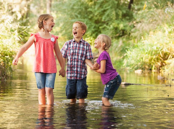 Three kids (4-5, 6-7) playing together in small stream