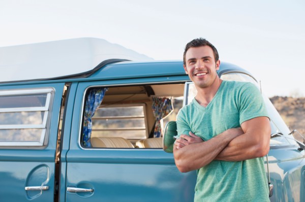 Man in front of his mini van during road trip