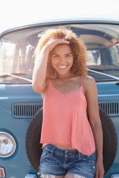 Portrait of smiling woman standing in front of van
