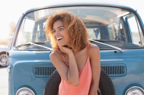 Smiling woman standing in front of van