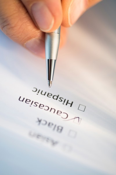 Close-up of hand filling out form.