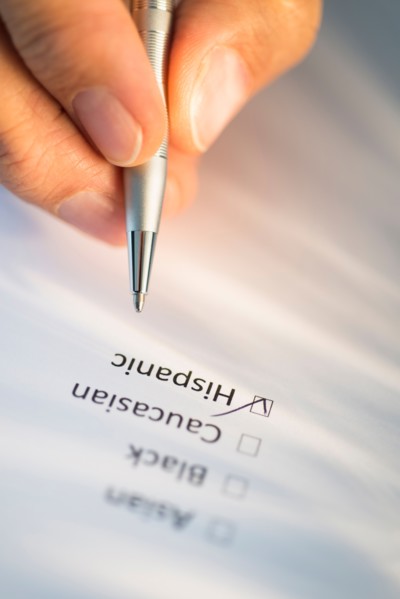 Close-up of hand filling out form.