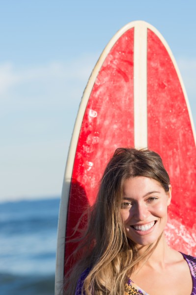 Portrait of woman with surfboard. Photo : Jamie Grill