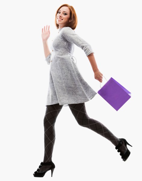 Young woman running with shopping bag, studio shot. Photo : Mike Kemp