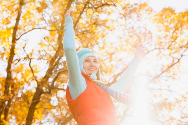 Happy young woman spinning in autumn forest. Photo : Mike Kemp