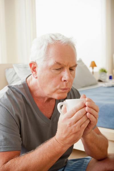 Senior man holding mug. Photo : Rob Lewine