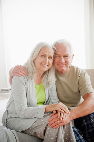 Portrait of senior couple sitting in bedroom. Photo: Rob Lewine