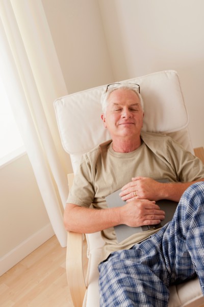 Senior man taking nap and holding book. Photo: Rob Lewine