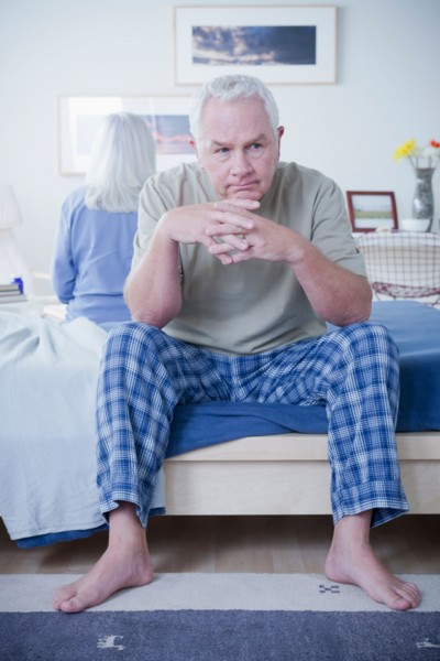 Senior couple after quarrel sitting on bed. Photo : Rob Lewine