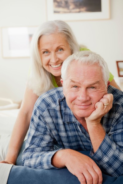 Portrait of senior couple laying on bed. Photo : Rob Lewine
