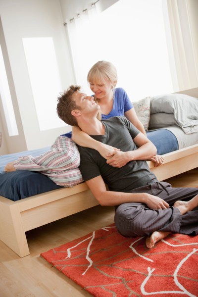Cheerful couple embracing in bedroom. Photo : Rob Lewine