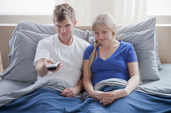 Couple watching television in bed. Photo : Rob Lewine