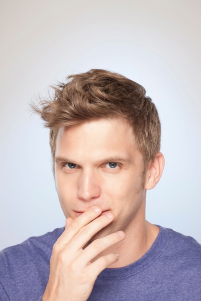 Portrait of man covering his mouth with hand. Photo: Rob Lewine