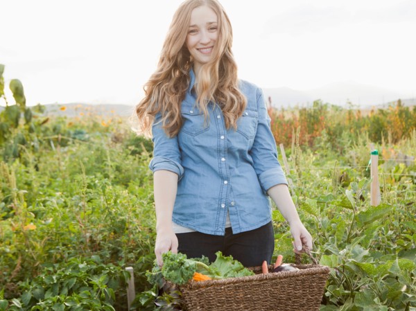 Portrait of young woman harvesting vegetables. Photo : Jessica Peterson