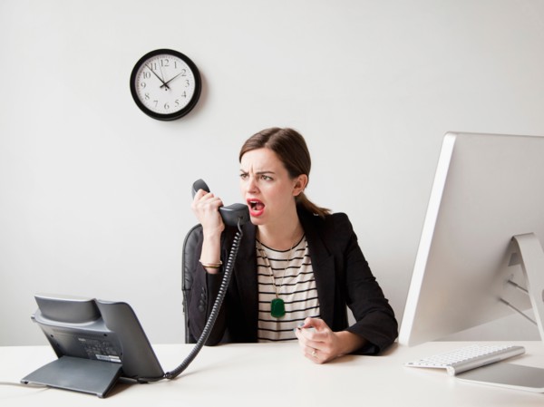 Studio shot of young woman working in office yelling into phone. Photo: Jessica Peterson