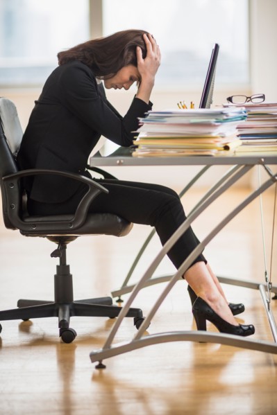 Businesswoman with head in hands.