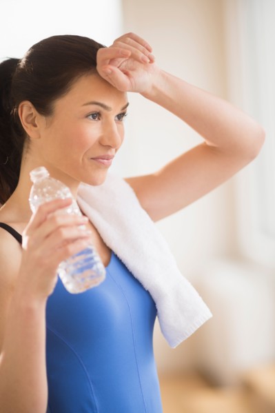 Woman drinking water in gym.
