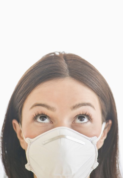 Studio portrait of woman wearing flu mask.