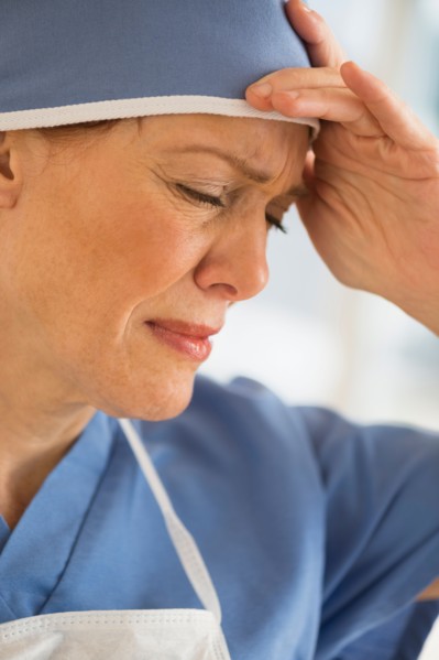 Female surgeon suffering headache.