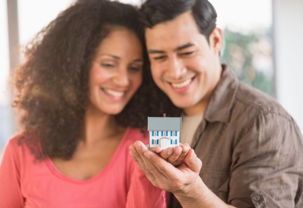 Smiling couple with model home.