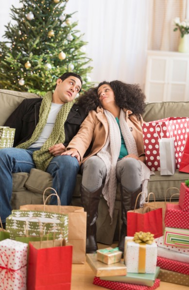 Couple with Christmas presents in living room.