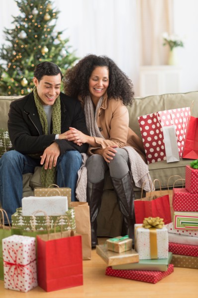 Couple with Christmas presents in living room.
