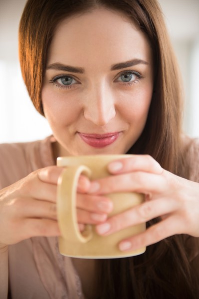 Portrait of young woman holding coffee cup
