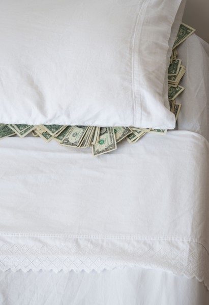 Dollar bills stacked under pillow