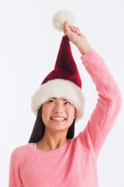 Portrait of teenage girl (16-17 years) wearing santa hat