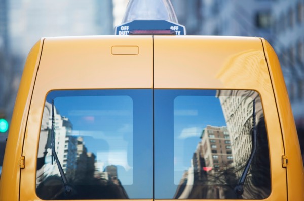 Reflection in rear window of yellow taxi
