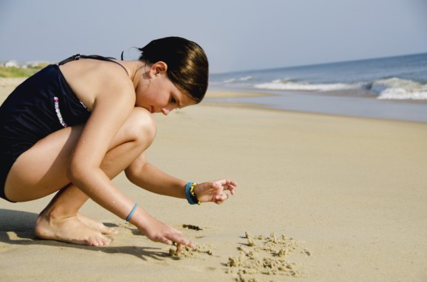 Girl (8-9) playing at beach