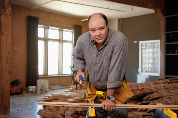 Man cutting piece of plank