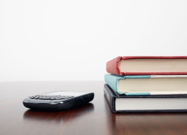 Mobile phone beside stack of books