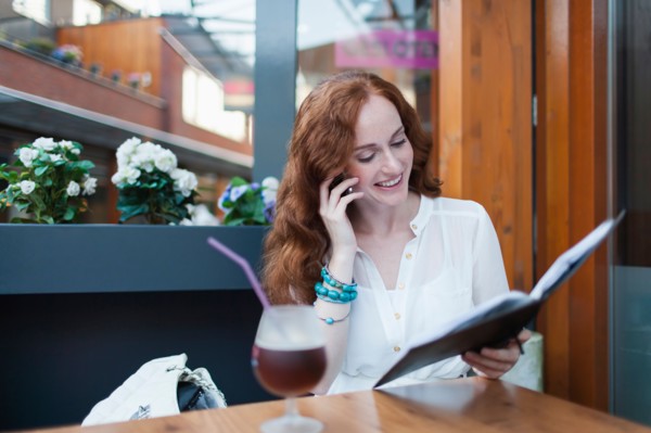 Elegant woman in cafe using mobile phone