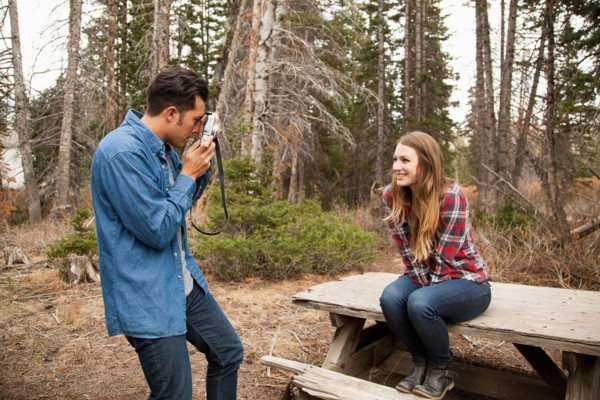 Young man photographing his girlfriend in non-urban scene