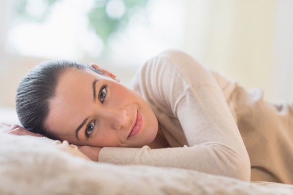 Portrait of woman lying on bed.