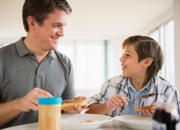 Father and son (8-9) eating lunch