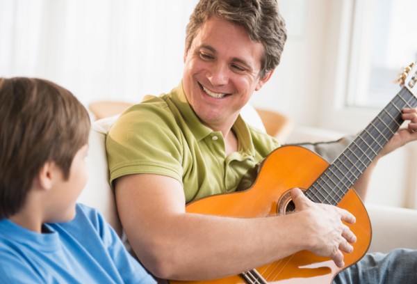 Father and son (8-9) playing guitar