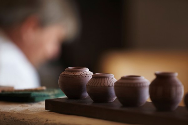 Small vases in row, man in background
