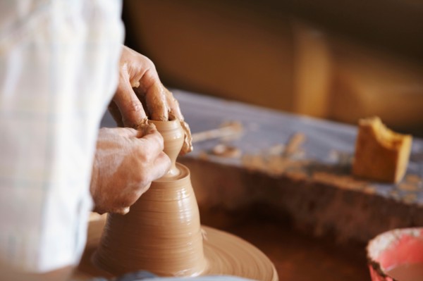 Hands working with clay on potter's wheel