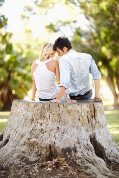 Couple sitting on tree stump