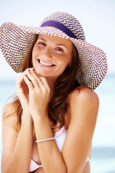 Portrait of young woman in bikini and straw hat